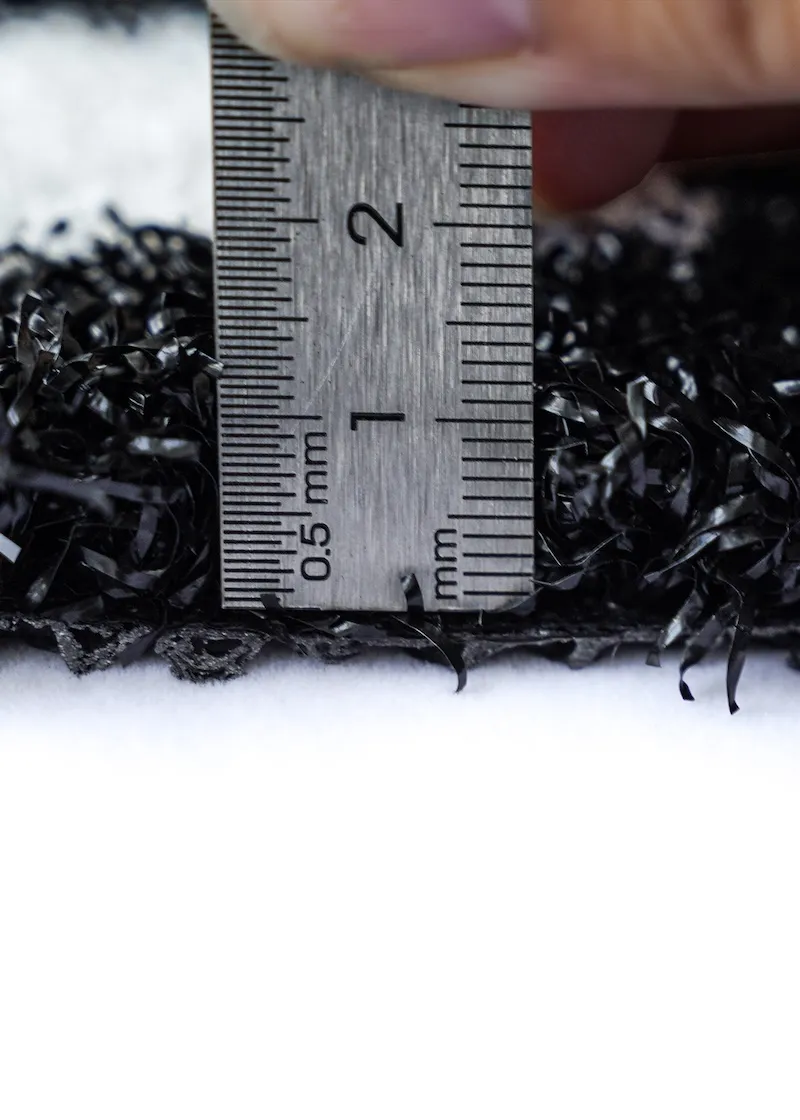 Quality inspection of green artificial turf during production.
