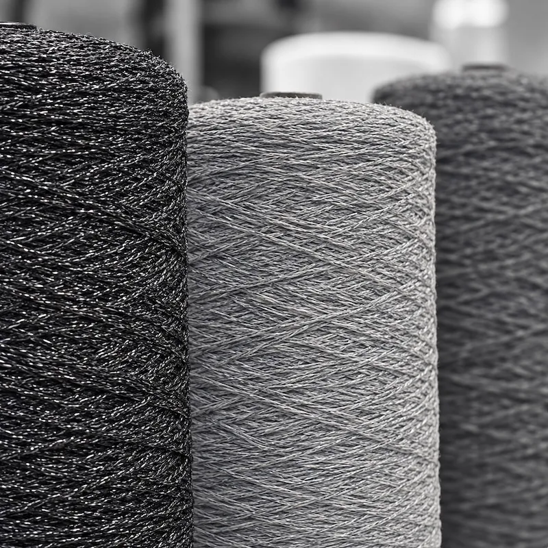 Green and white yarn rolls used for artificial turf production.