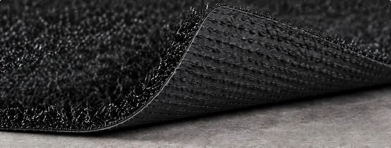 Close-up of standard SBR backing on short-pile sled training turf.