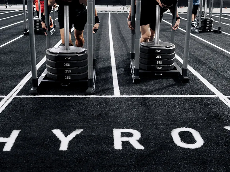 Custom green sled turf lane with tufted start line, distance markings and white lane boundaries.